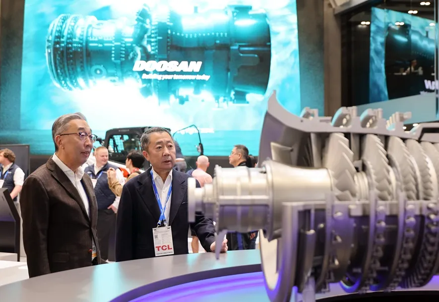 Doosan Group Chairman Jeongwon Park (right) and Group Vice Chairman Geewon Park (left) inspect a gas turbine model on display at the Doosan booth at CES 2026 in Las Vegas, Nevada, United States, on January 7.